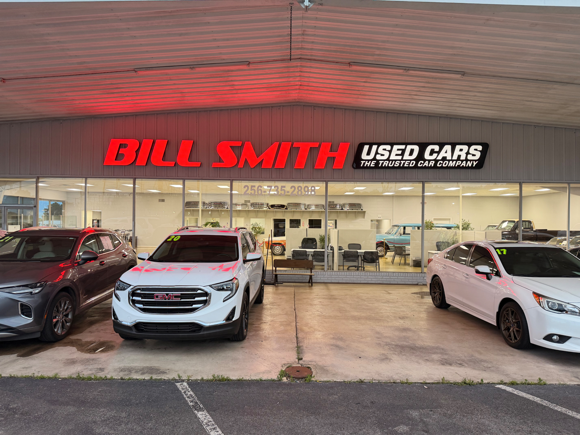 Bill Smith Used Cars storefront with vehicles out front
